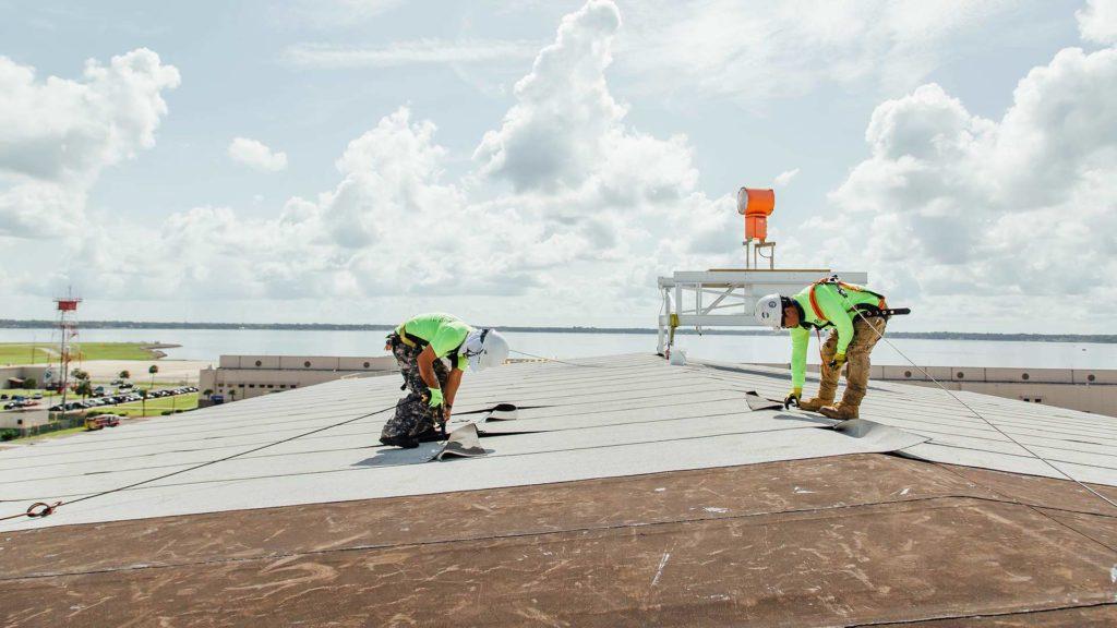 Commercial roofing professionals inspecting a large flat roof system